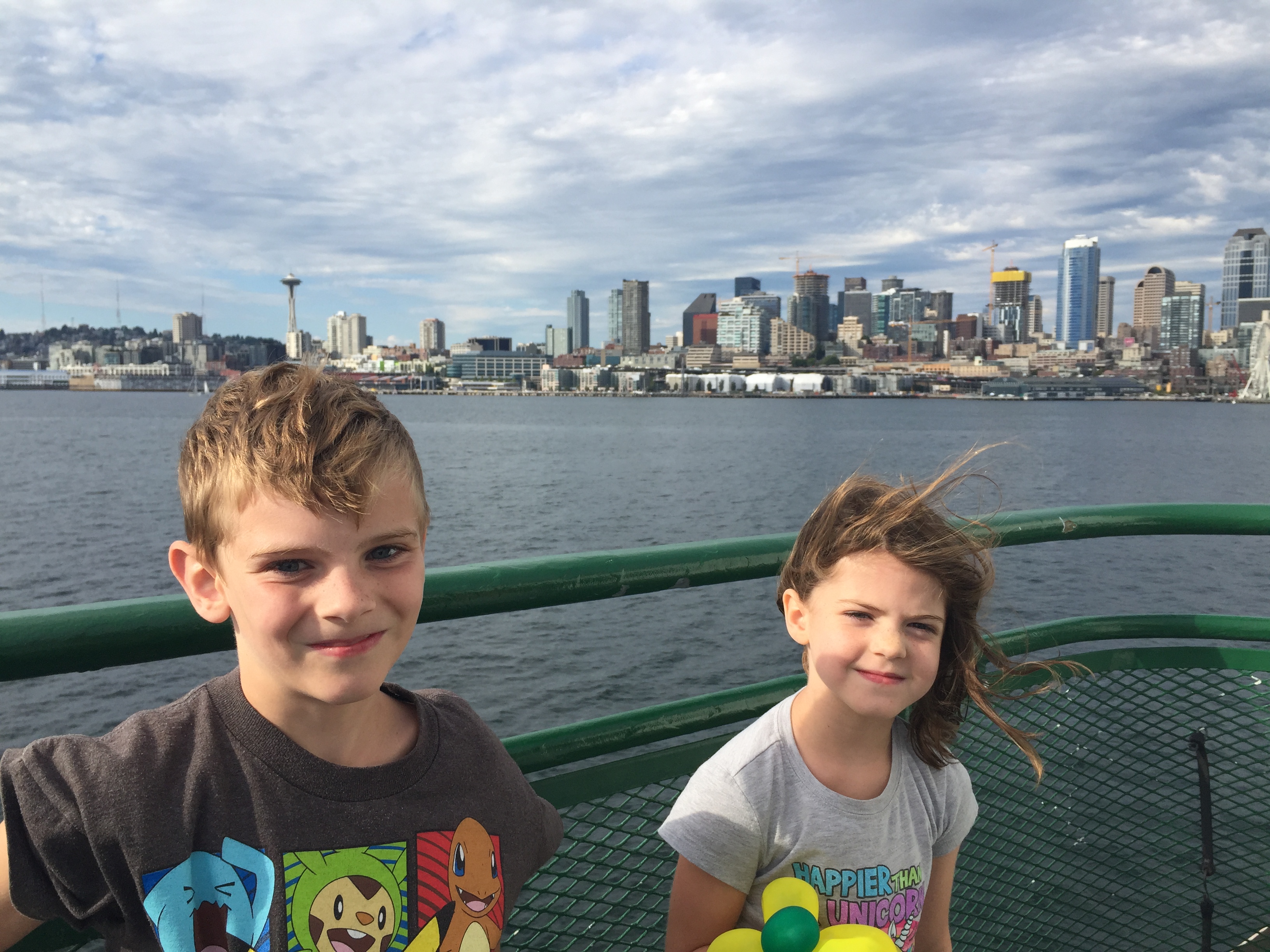 A boy and A Girl ride a ferry with the Seattle Skyline in the background